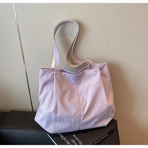 Close-up of lavender nylon tote bag featuring JUMAITU logo on textured background