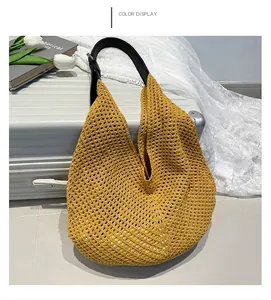 Detail of yellow woven hobo bag showing large mesh crochet pattern and leather strap