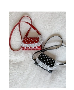 Detailed view of red and black polka dot crossbody bags with delicate lace trim