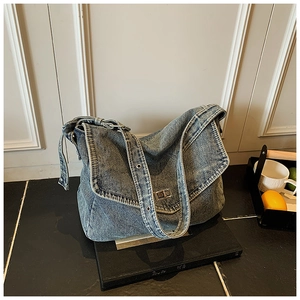 Dettaglio borsa tote in denim blu vintage con chiusura a scatto e tracolla con occhielli