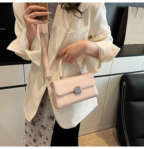Detailed close-up of light pink leather handbag showing smooth texture and silver buckle