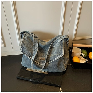 Dettaglio della borsa tote in denim blu con chiusura girevole in argento e tessuto morbido