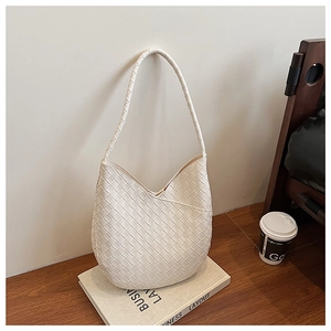 Détail du sac à bandoulière tressé blanc en forme de croissant sur fond minimaliste