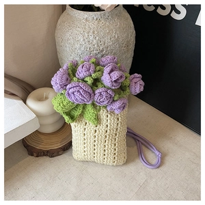 Detail of handmade knit phone bag featuring crochet purple rose and cream texture