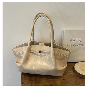 Detail van beige shopper met krokodillenpatroon, kunstleer textuur en gouden gesp