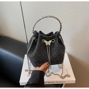Detail of denim bucket bag with rhinestones, silver butterfly buckle and pearl drawstrings