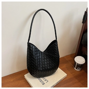 Détail macro du sac hobo en cuir tressé noir de haute qualité sur fond minimaliste