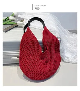 Macro view of red crochet tote bag featuring hollow mesh weave and leather straps