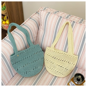Detail showing handwoven sage green and cream yellow crochet tote bags on a sofa