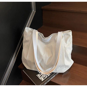 Detail of light blue canvas tote bag showing textured fabric and brand logo on stairs
