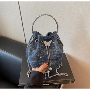 Detail of blue denim bucket bag with sparkling rhinestones and silver ring handle