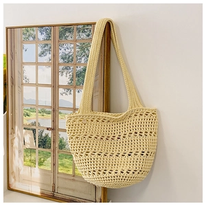 Close-up of beige crochet tote bag with hollow grid texture and wooden button detail