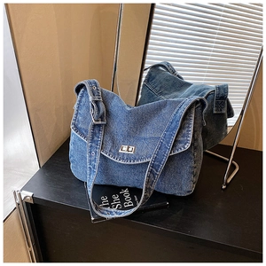 Dettaglio della borsa a tracolla in denim blu lavato con chiusura a scatto argentata