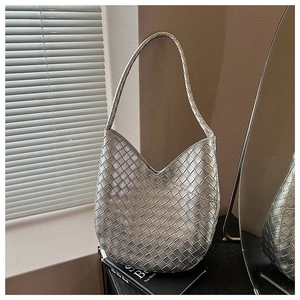 Vue détaillée de la texture tressée argentée et de la finition métallique de ce sac chic