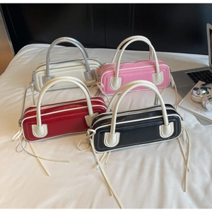 Detail of four glossy leather bowling bags in silver, pink, red, and black colors
