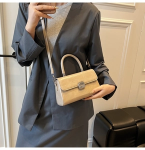 Detail of light beige PU leather square handbag with top handle and silver buckle clasp