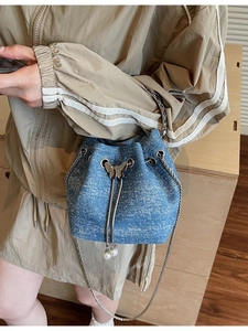 Blue denim bucket bag with silver glitter, pearl tassels, and a butterfly buckle