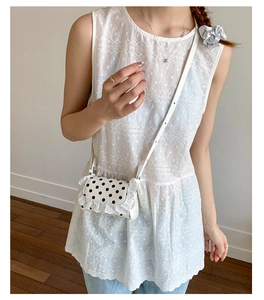 Detailed view of the white lace-trimmed polka dot mini crossbody bag on model