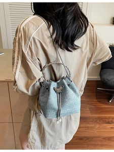 Blue sequin woven bucket bag with metal chain strap and pearl bow charm detail