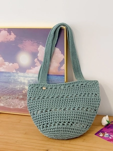 Green knit hollow tote bag with a wooden button on a rustic wooden table background
