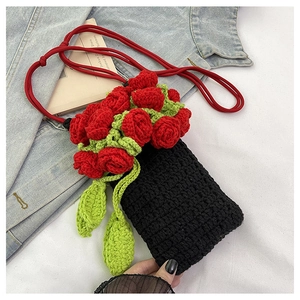 Detail of handmade knit phone bag featuring 3D crochet red roses and green leaves