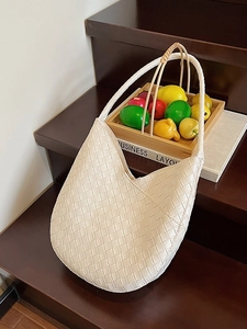 Sac bandoulière minimaliste en cuir tressé beige de forme croissant pour un look élégant