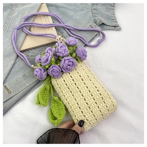 Detailed close-up of handmade cream knit bag with 3D purple roses and green leaves
