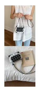 Close-up of black polka dot mini bag with white lace trim and minimalist thin strap