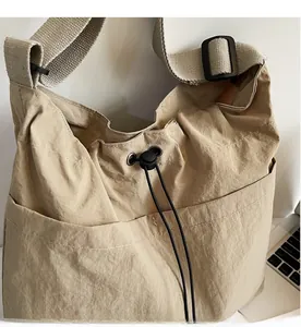 Detail view of khaki crossbody bucket bag with drawstring closure and adjustable strap