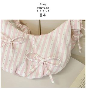 Close-up of pink and white striped shoulder bag with bows and ruched detail
