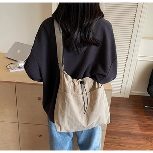Detail of khaki fabric drawstring bucket bag with large pockets and natural texture