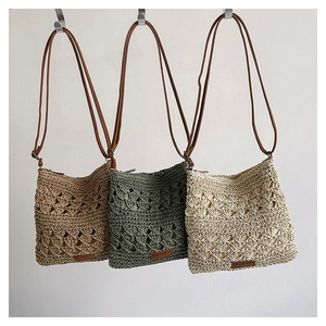 Detail view of woven crossbody bags in khaki, dark green, and off-white with leather straps