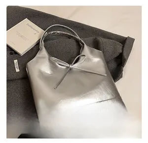 Detail view of the silver PU leather tote bag with a minimalist bow and smooth texture