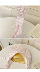 Detail of pink striped canvas bag showing ruffled strap and yellow inner lining with zip pocket