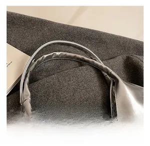 Close-up of the smooth metallic silver PU leather handle and fine texture on this tote bag