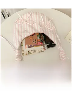 Pink and white striped crescent bag with bow details and interior capacity view