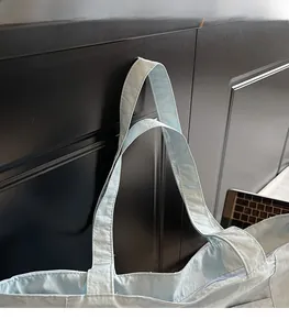 Close-up of light blue tote bag shoulder straps and sturdy stitching on canvas material