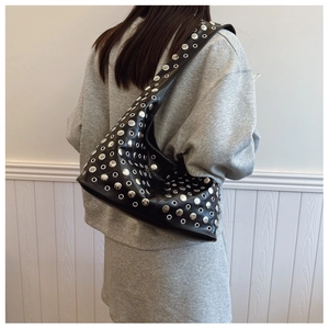 Detailed view of punk bucket bag with silver metal eyelets and rivets on black faux leather