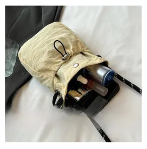 Internal capacity view of beige bucket bag showing smartphone and cosmetics storage space