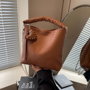Caramel brown woven bucket bag with thick handle and silver chain strap for women