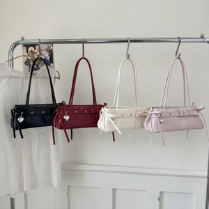 Detail showing four colors of glossy Y2K shoulder bags with heart charms and bows