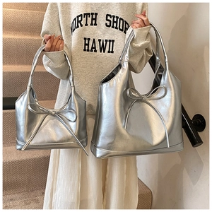 Detailed comparison of small and large silver bow tote bags with metallic finish