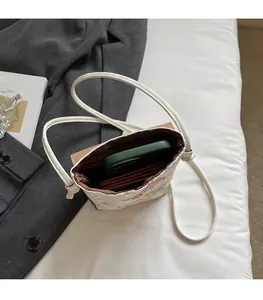 Vue de dessus du sac à téléphone brodé montrant l'intérieur spacieux avec mobile et portefeuille