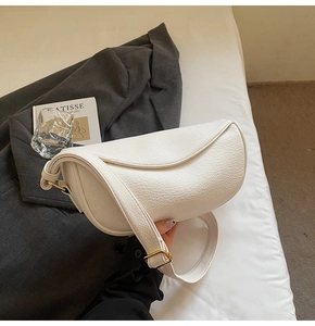 Dettaglio della borsa a mezzaluna in pelle litchi bianca con fibbie dorate metalliche