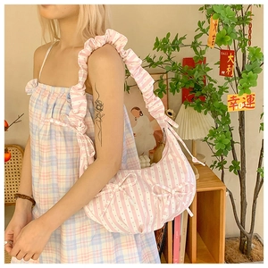 Close-up of pink and white striped hobo bag with bow details and ruched handle texture