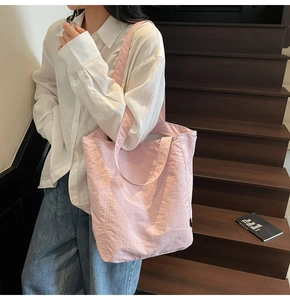 Pink canvas tote bag shown as a shoulder bag style on model for daily commuting