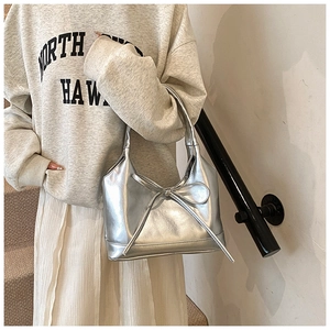 Close-up of metallic silver PU tote bag featuring a minimalist bow knot and sleek finish