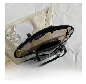 Detail view of transparent PVC tote bag with black leather trim and inner pouch
