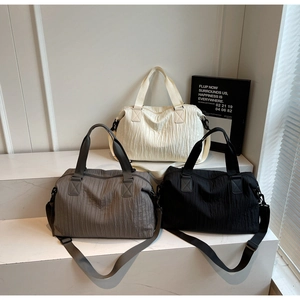 Detailed view of large canvas tote bags with pleated texture in cream, grey and black