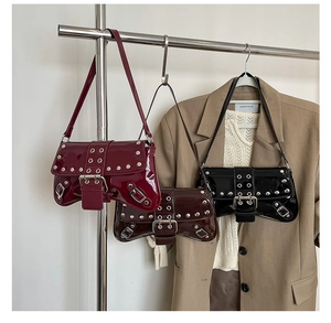 Detail of patent leather underarm bags with vintage silver rivets and metallic buckle